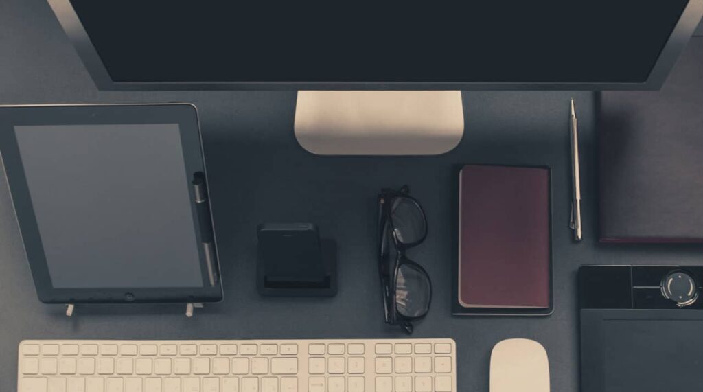 Picture of a desk with several devices on it (tablet